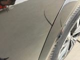a close up of a car ' s front tire with a man working on it