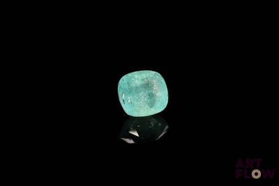 a close up of a green diamond on a black surface