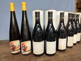 several bottles of wine are lined up on a wooden table