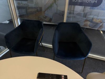 two chairs and a table with a remote control on it