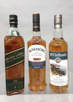 trois bouteilles de whisky posées sur une étagère en verre