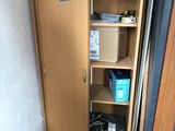 a cabinet with a door open in the corner of a room