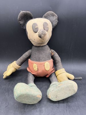 mickey mouse plush toy sitting on a black surface