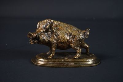 figurine en bronze représentant un sanglier sur un socle, sur fond noir