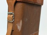 a close up of a brown suitcase on a white surface