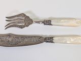 two forks and a knife on a white surface