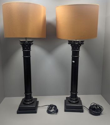 pair of black lamps with beige shades on a white table