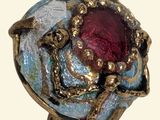 an image of a ring with a red stone in it