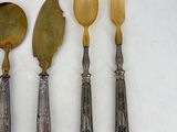 four silverwares and spoons are lined up on a white surface