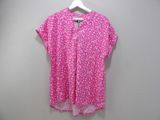 pink polka dot print blouse with white polka dots on it