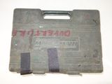 an old metal case with a handle on a white surface