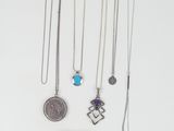 various necklaces and bracelets laid out on a white surface