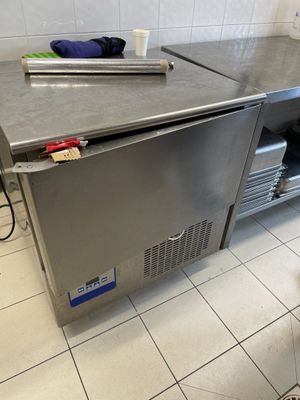 plan de travail en acier inoxydable dans une cuisine professionnelle avec un sol carrelé