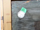 un morceau de papier sur lequel est collé un autocollant, posé sur un morceau de bois