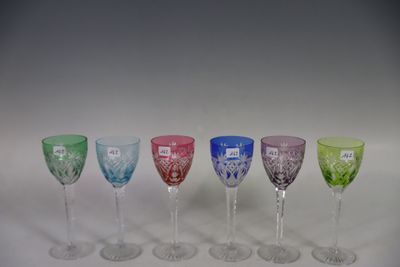 several different colored wine glasses are lined up in a row