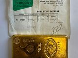 a gold bar sitting on top of a piece of paper