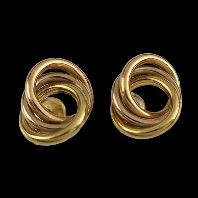 deux paires de boucles d'oreilles dorées sur fond noir