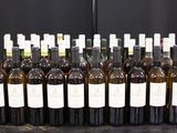 Des bouteilles de vin sont alignées sur une table devant un fond noir.