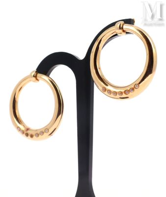 pair of black and gold hoop earrings on a black stand