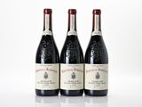 three bottles of wine sitting on top of a white table