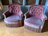 une paire de fauteuils recouverts de velours rose devant une fenêtre