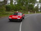 a red car that is driving down the road