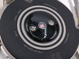 a close up of a watch on a white surface