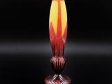 un vase orange et jaune posé sur une table noire