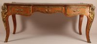 Bureau plat de forme galbée, en bois de placage marqueté.