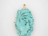 un pendentif en forme de dragon en jade turquoise, monté sur une chaîne plaquée or