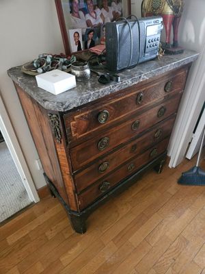 une commode en bois avec un plateau en marbre dans une chambre