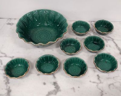 green ceramic bowls and bowls with gold rims on a marble surface