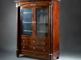 an antique mahogany display cabinet with glass doors and drawers
