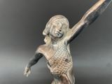 bronze statue of a woman holding a tennis racquet in her hand