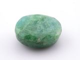 an image of a green stone on a white surface