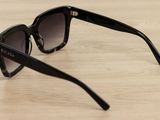 black sunglasses on a wooden table with a white background