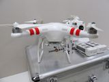 a white and red drone sitting on top of a metal case