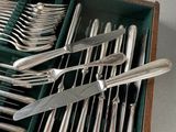 a lot of silverware in a green box on the table