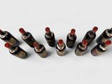 six bottles of wine lined up in a row on a white surface