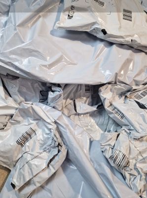 une pile de sacs remplis de vêtements par terre