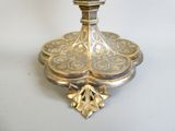 a silver and gold candle holder on a white table