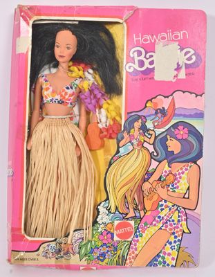 une image représentant une poupée Barbie dans une boîte rose, vêtue d'une jupe de hula
