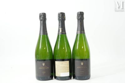 trois bouteilles de vin posées les unes à côté des autres sur une surface blanche