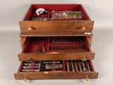 a wooden box with two drawers filled with silverware