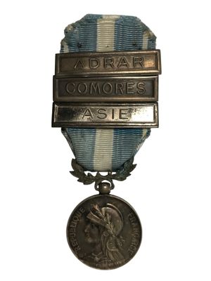 une vieille médaille en argent entourée d'un ruban bleu et blanc