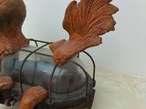 a statue of a man riding a motorcycle with a bird on the back