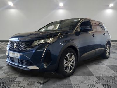 une voiture bleue est garée dans une pièce au sol à carreaux