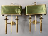 pair of brass sconces with green velvet shades on them