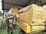 un tracteur qui est garé dans l'herbe, sous un bâtiment