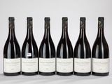 six bouteilles de vin sont alignées sur une table